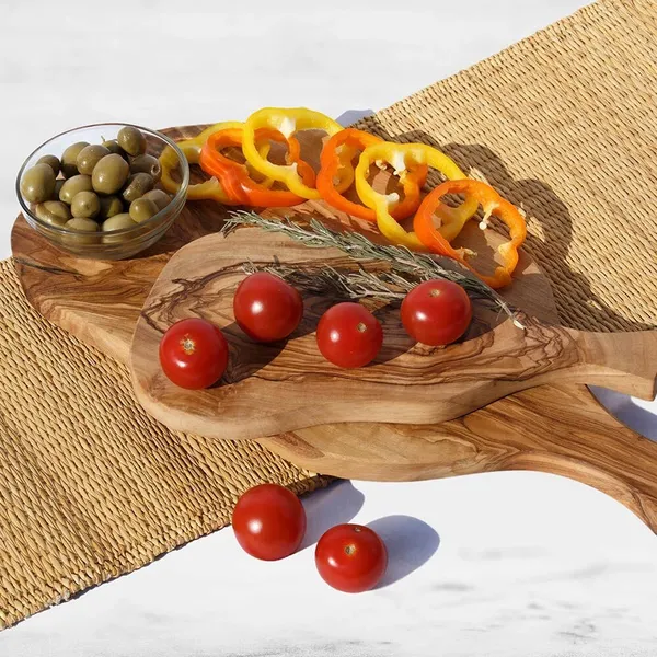 Wooden serving boards with tomatoes, olives, and fresh herbs